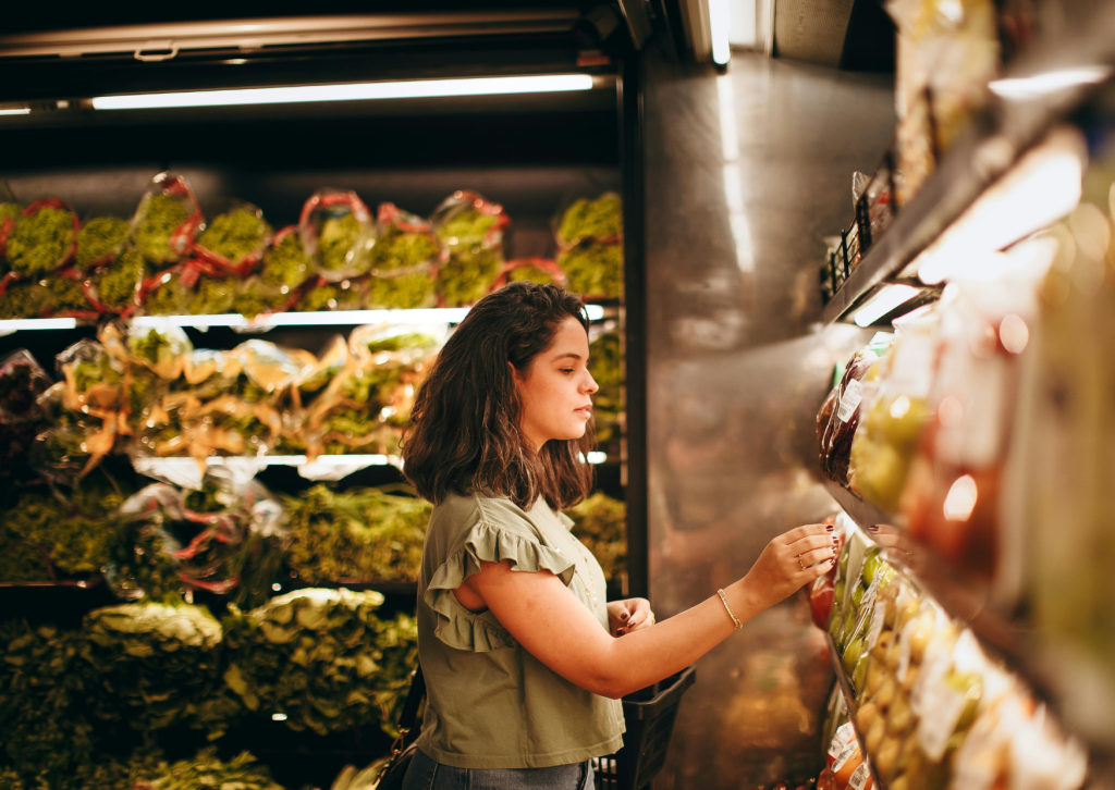 Young lady looking at fresh produce in a grocery store